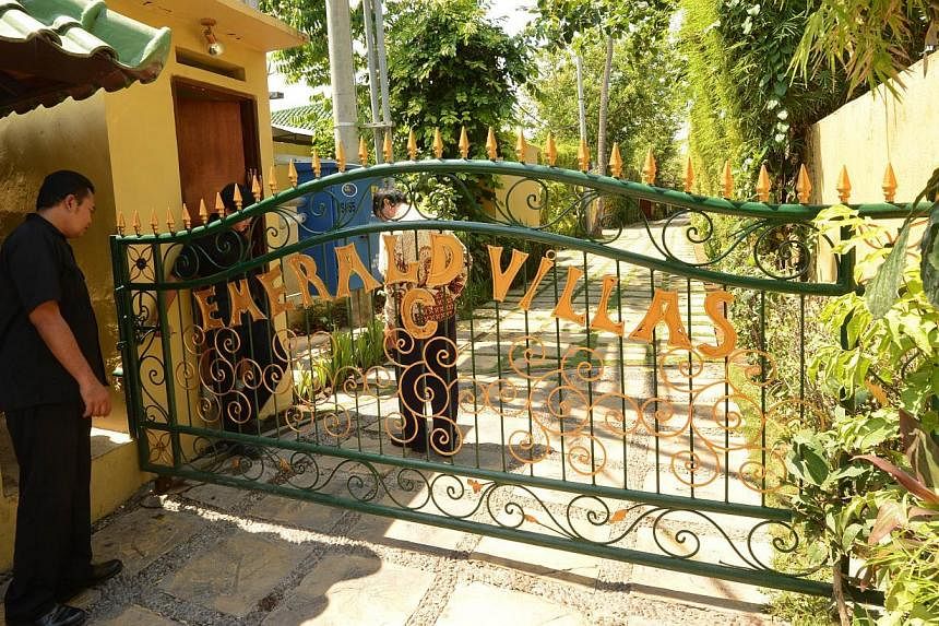 Security guards stand at the front gate of Emerald villas in Sanur on Bali island on Oct 22, 2014. -- PHOTO: AFP