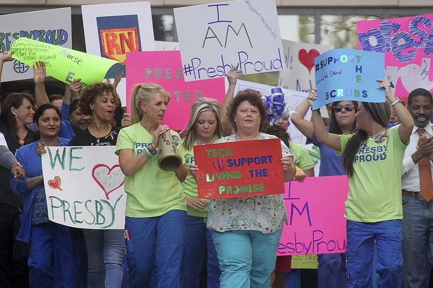 Nurses and health care staff hold a rally in support of their colleagues Nina Pham and Amber Vinson, who are now in treatment after contracting the Ebola virus, outside the Texas Presbyterian Hospital in Dallas on Oct 17, 2014. -- PHOTO: REUTERS