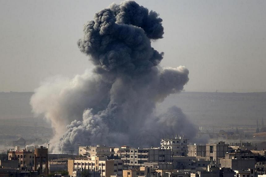 Smoke rises from the Syrian town of Kobani, seen from near the Mursitpinar border crossing on the Turkish-Syrian border in the southeastern town of Suruc in Sanliurfa province on Oct 14, 2014. -- PHOTO: REUTERS