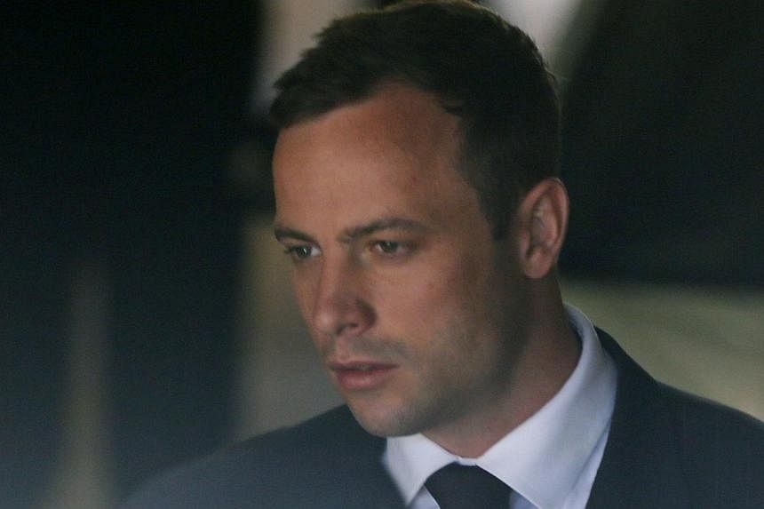 South African Olympic and Paralympic sprinter Oscar Pistorius is led to a prison van after his sentencing in Pretoria on Oct 21, 2014. Pistorius was sentenced to five years in prison on Tuesday for killing his girlfriend Reeva Steenkamp, ending a tri