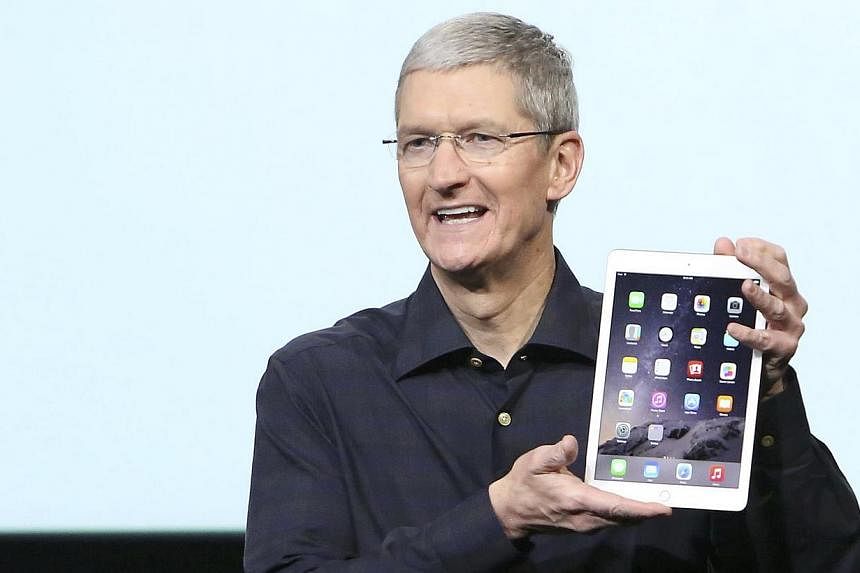 Apple CEO Tim Cook holds an iPad during a presentation at Apple headquarters in Cupertino, California. -- PHOTO: REUTERS&nbsp;
