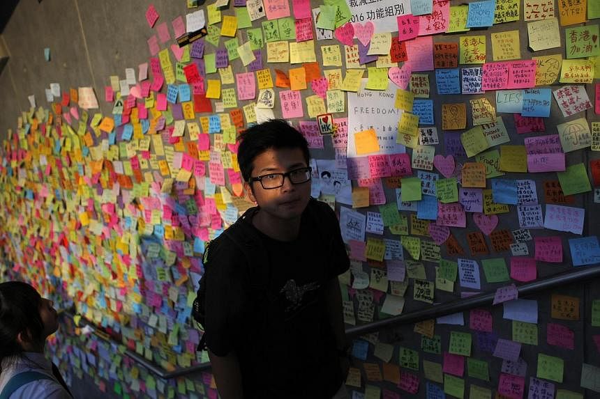A man walks past messages of support for the pro-democracy demonstrations on a wall, as protesters block areas around the government headquarters in Hong Kong, on Oct 6, 2014. -- PHOTO: REUTERS