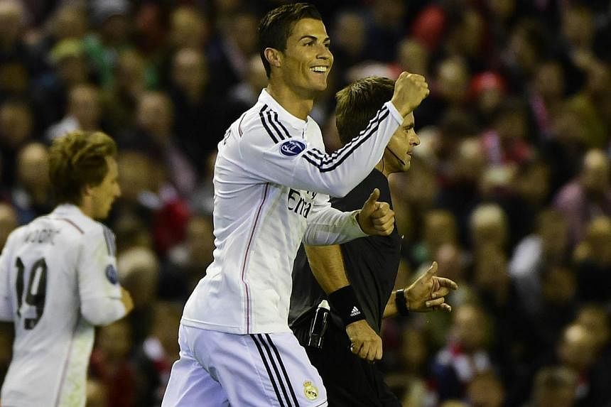 Real Madrid's Portuguese forward Cristiano Ronaldo celebrates scoring the opening goal during the Uefa Champions League, group B, football match between Liverpool and Real Madrid at Anfield in Liverpool, northwest England, on Oct 22, 2014. -- PHOTO: 