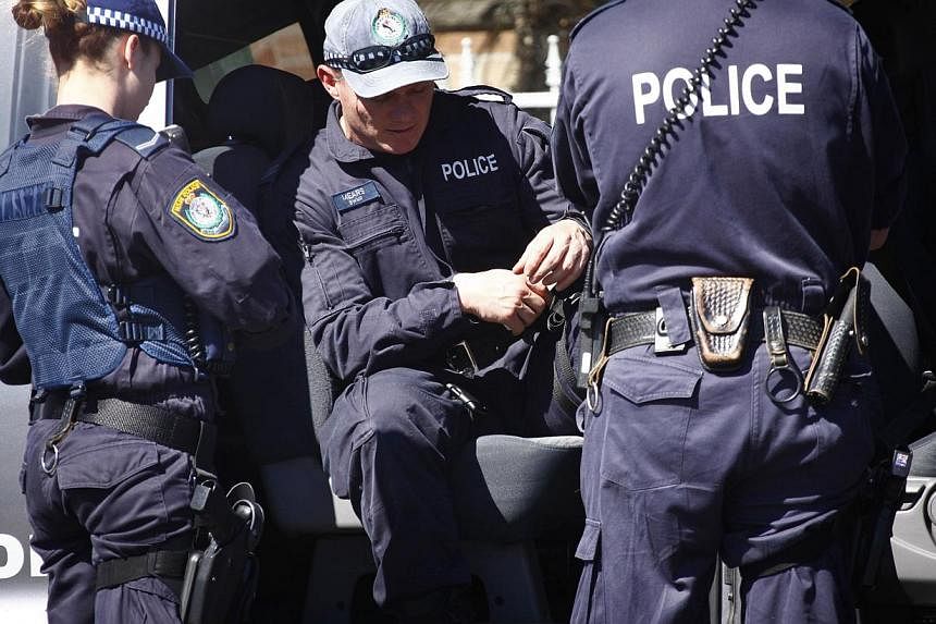 Police outside a house that was involved in pre-dawn raids in western Sydney on Sept 18, 2014. Australia has stepped up security around Parliament House after a gunman attempted to storm Canada's legislature. -- PHOTO: REUTERS