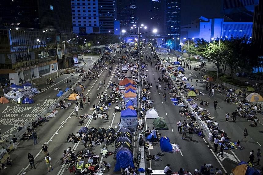 Protesters of the Occupy Central movement sleep in tents as pro-democracy protesters continue blocking areas around the government headquarters building in Hong Kong on Oct 11, 2014. -- PHOTO: REUTERS