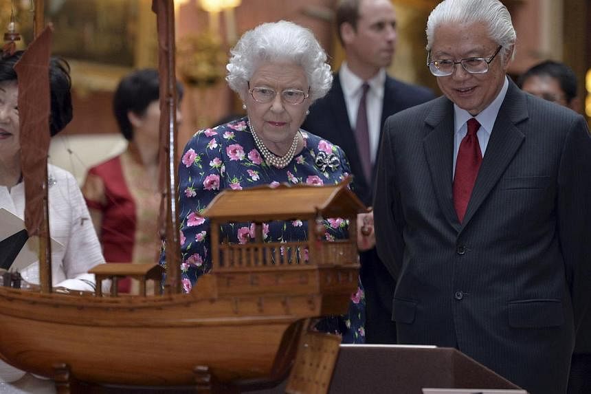 Britain's Queen Elizabeth and Singapore's President Tony Tan view a display of Singaporean items from the Royal Collection at Buckingham Palace in London on Oct 21, 2014. -- PHOTO: REUTERS