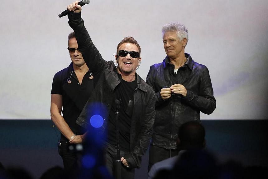 Bono (centre) of Irish rock band U2 gestures to the audience after performing at an Apple event at the Flint Center in Cupertino, California on Sept 9, 2014. -- PHOTO: REUTERS