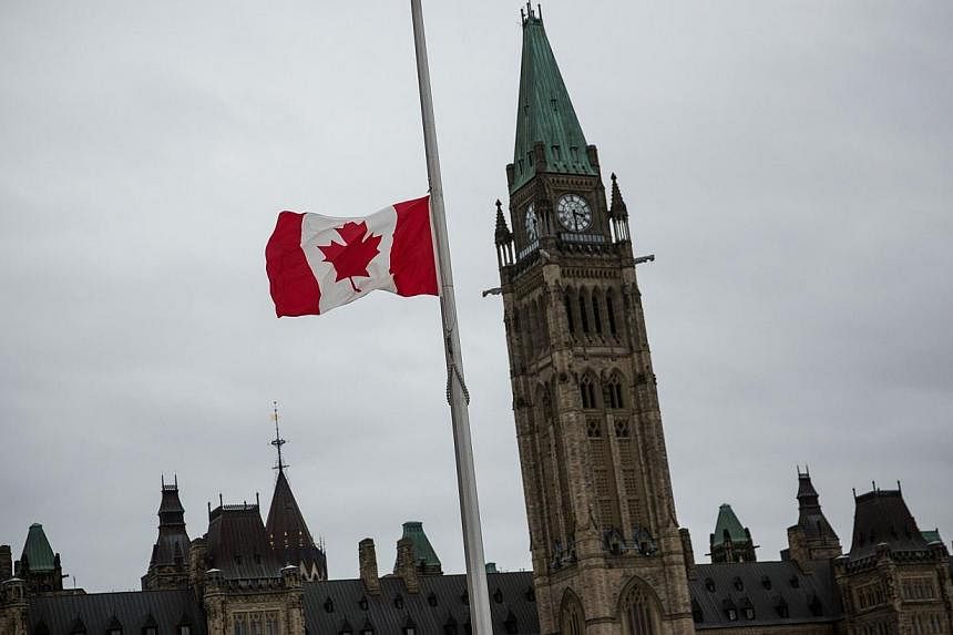 A flag next to the Canadian Parliament Building is flown at half staff one day after Cpl. Nathan Cirillo of the Canadian Army Reserves was killed while standing guard in front of the National War Memorial by a lone gunman in Ottawa, Canada on Oct 23,