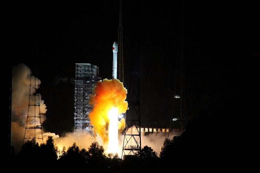 A rocket carrying an experimental spacecraft launches from Xichang space base in Xichang, south-western China's Sichuan province, on Oct 24, 2014. -- PHOTO: AFP&nbsp;