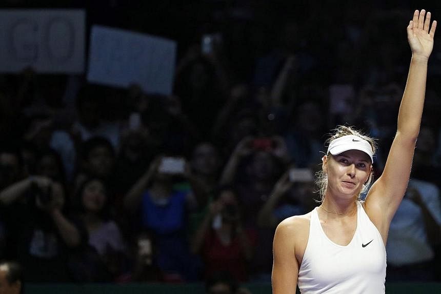 Maria Sharapova of Russia acknowledges the crowd after defeating Agnieszka Radwanska of Poland during their WTA Finals singles tennis match at the Singapore Indoor Stadium on Oct 24, 2014.&nbsp;Maria Sharapova recovered from a second-set meltdown to 