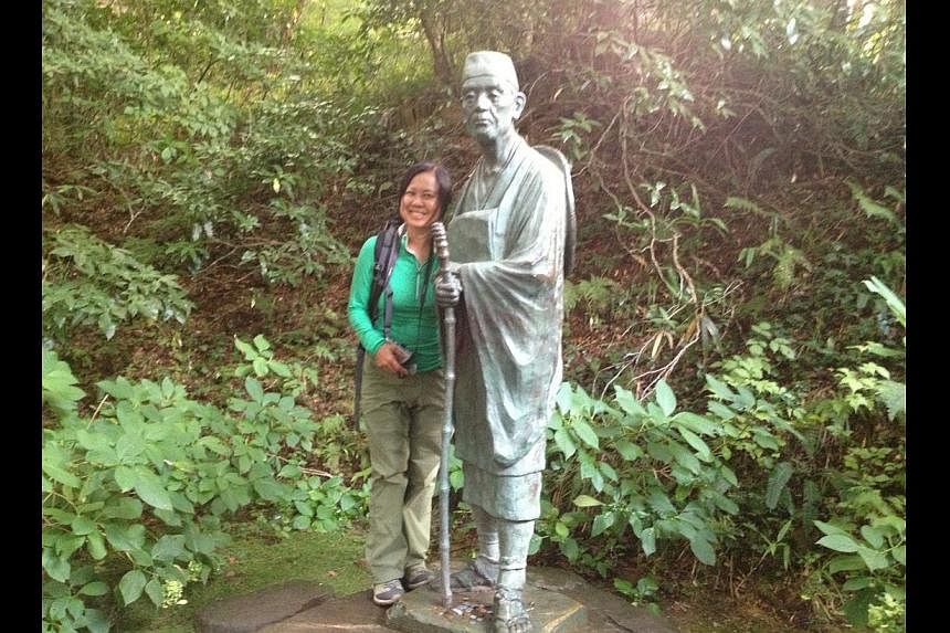 Ms Lee Siew Hua stops for a photo in Japan with a statue of 17th-century poet Matsuo Basho. She has covered five continents as ST's travel writer.