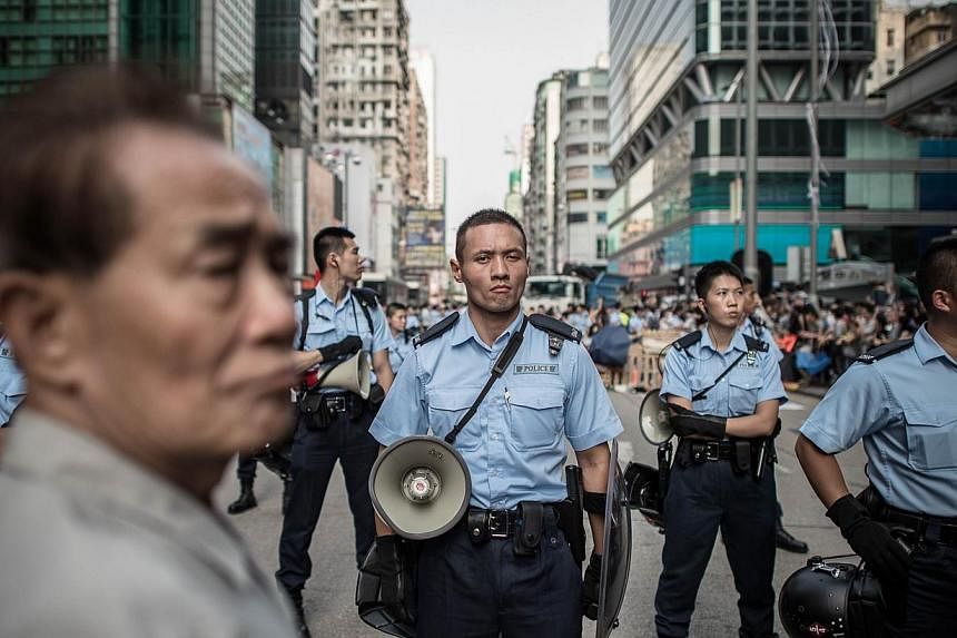 Hong Kong's police officers, regarded as among the cleanest and best paid in the world, are not used to being seen as public enemies. They are supposed to be the good guys but, overnight, they have become a subject of scorn. -- PHOTO: AGENCE FRANCE-P