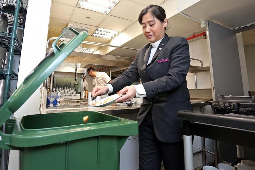Ms Daphne Seet, 35, a conference and banqueting team leader at Crowne Plaza Changi Airport, separating food waste from general waste at the banquet kitchen.