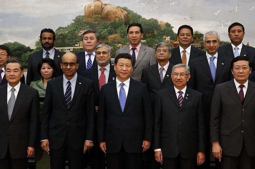 Chinese President Xi Jinping (C) takes photos with guests of the Asian Infrastructure Investment Bank at the Great Hall of the People in Beijing on October 24, 2014. -- PHOTO: AFP