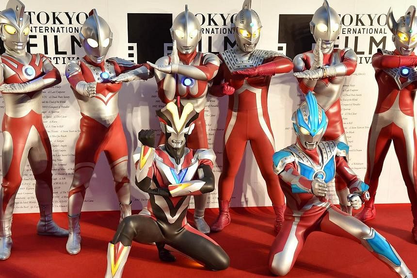 Actors clad in body suits of Ultrman series characters pose on the red carpet for the 27th Tokyo International Film Festival opening ceremony in Tokyo on Oct 23, 2014. -- PHOTO: AFP&nbsp;