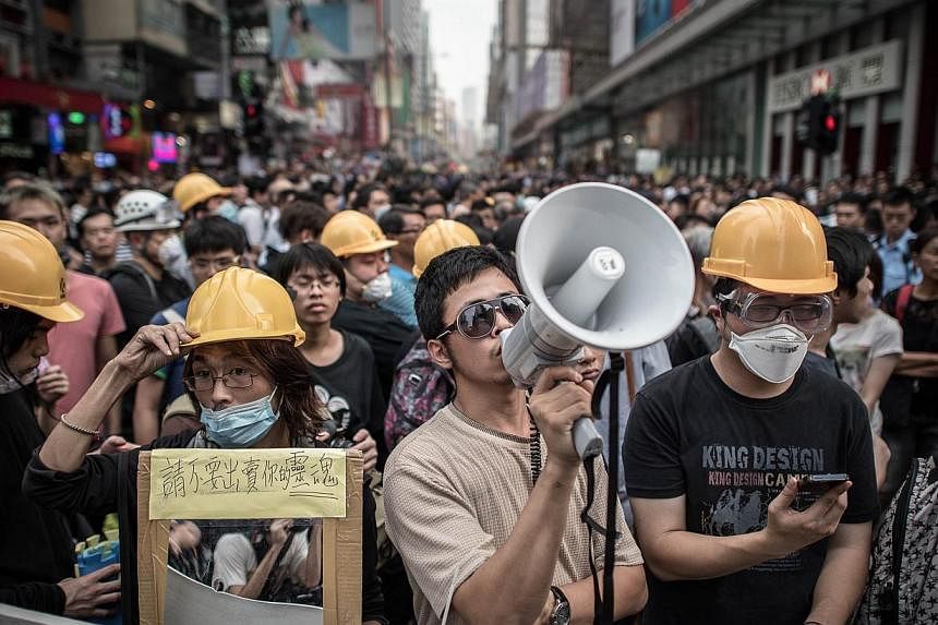Pro-democracy demonstrators guarding a barricade in the Mongkok district of Hong Kong on October 22, 2014. The&nbsp;organisers of the Occupy movement will organise a poll among protesters this Sunday, to seek their opinions on the 2017 chief executiv