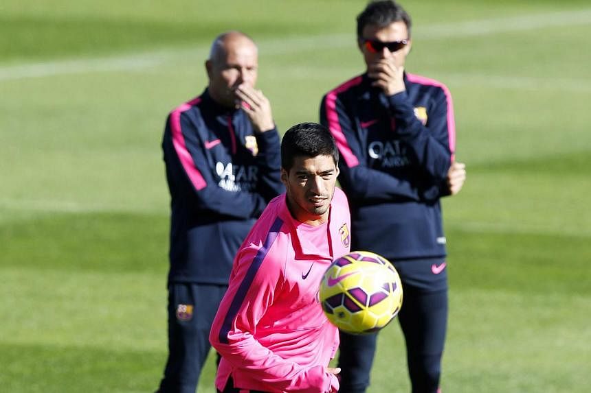 Barcelona's coach Luis Enrique (back right) and his assistant looks at Luis Suarez (front) during a training session at Ciutat Esportiva Joan Gamper in Sant Joan Despi near Barcelona on Oct 24, 2014. -- PHOTO: REUTERS