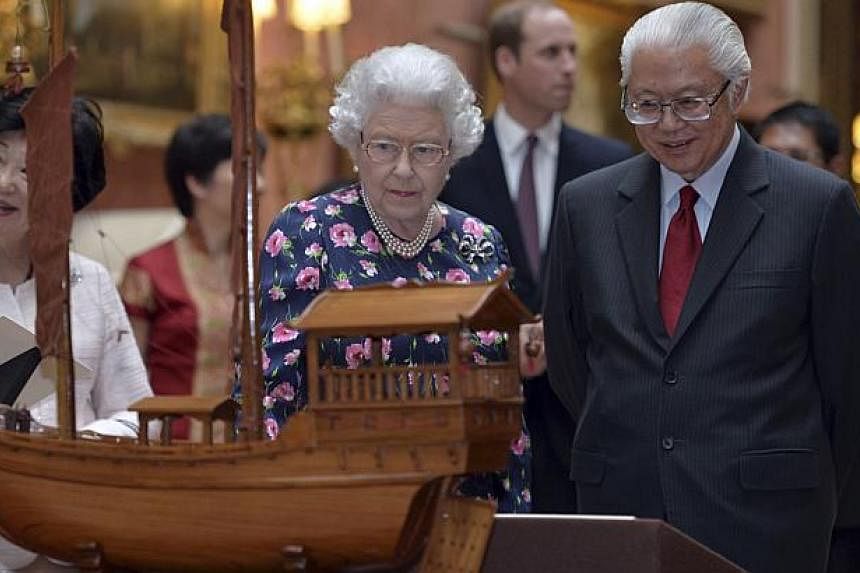Britain's Queen Elizabeth II and President Tony Tan Keng Yam view a display of Singaporean items from the Royal Collection at Buckingham Palace in London on Oct 21, 2014. -- PHOTO: REUTERS