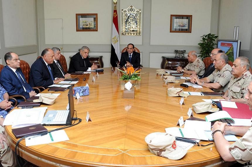 Egypt's President Abdel Fattah al-Sisi (centre) chairs a meeting with the National Defence Council in Sheikh Zuweid, North Sinai on Oct 24, 2014. A car bomb in Egypt's Sinai Peninsula killed at least 28 soldiers, in one of the deadliest attacks on se