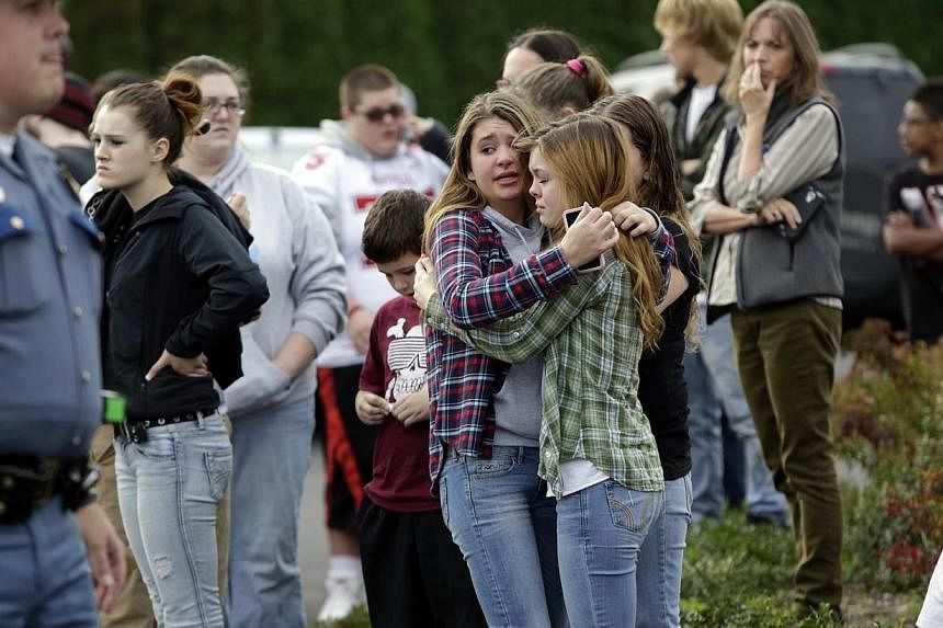Two girls hug at Shoultes Gospel Hall church where families are reuniting after an active shooter situation at Marysville-Pilchuck High School in Marysville, Washington on Oct 24, 2014. -- PHOTO: REUTERS