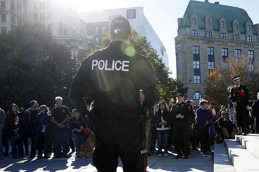 Police officers attend a ceremony returning sentries to the Tomb of the Unknown Soldier at the National War Memorial in Ottawa on Oct 24, 2014. -- PHOTO: REUTERS