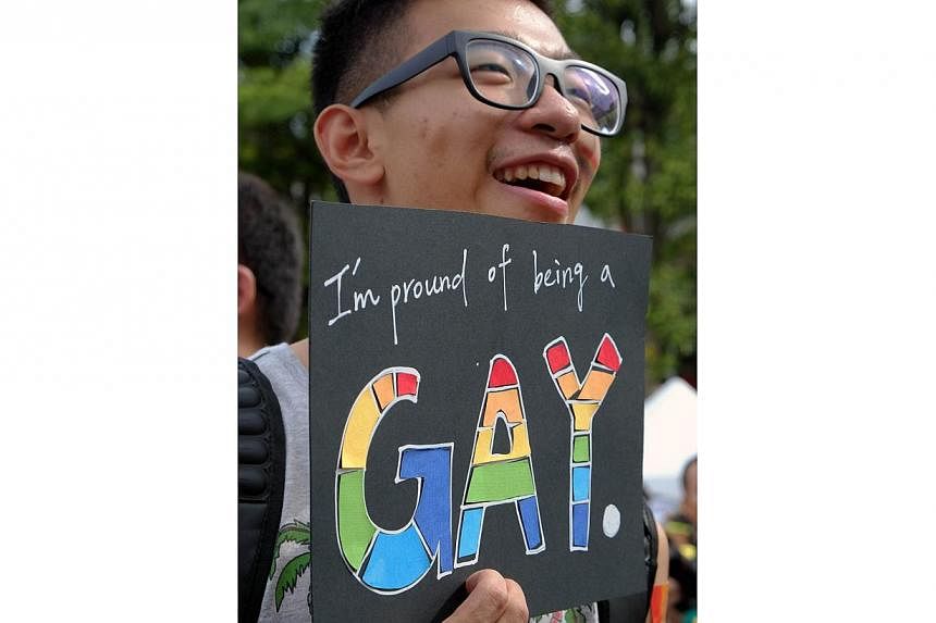 A participant displays a placard during the annual gay parade in Taipei on Oct 25, 2014. -- PHOTO: AFP