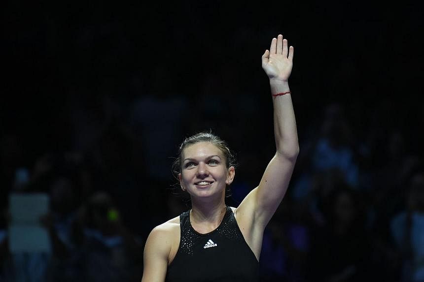 Simona Halep of Romania waves to supporters after defeating Agnieszka Radwanska of Poland during the semi finals of the Women's Tennis Association (WTA) finals in Singapore on Oct 25, 2014. -- PHOTO: AFP