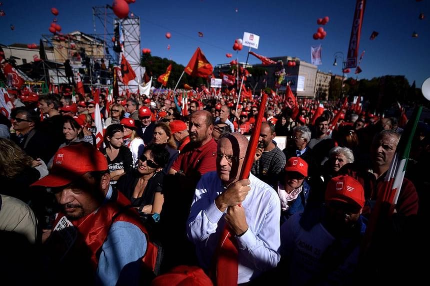 People stand in San Giovanni square during a demonstration organised by Italian General Confederation of Labour (CGIL) union on Oct 25, 2014 in central Rome as part of a nationwide protest called by the union to protest Prime Minister Matteo Renzi's 