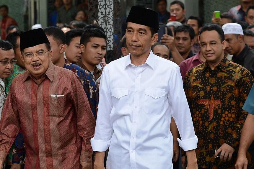 Indonesian President Joko Widodo (centre) with Vice-President Jusuf Kalla (left) and Anies Baswedan (right), a senior member of Mr Widodo's presidential campaign team. -- PHOTO: AFP