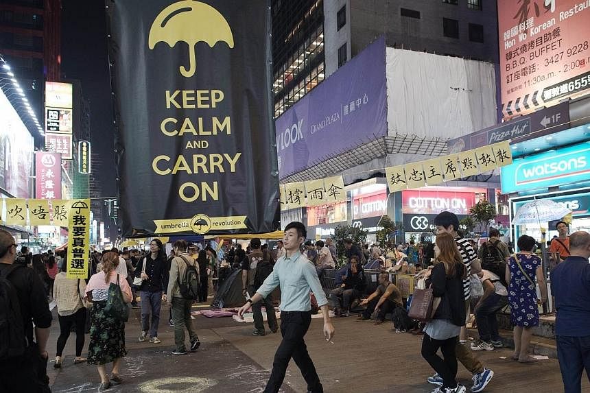 A giant banner that reads "keep calm and carry on" is displayed in a street in the campsite of pro-democracy protesters in the Mongkok district of Hong Kong on Oct 25, 2014. -- PHOTO: AFP