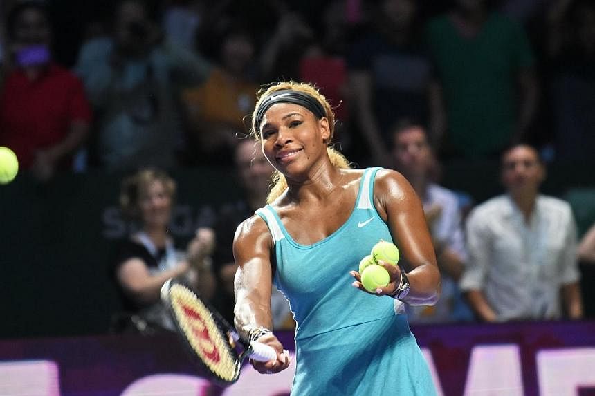 Two-time defending champion Serena Williams hits balls out to the audience after she beat Caroline Wozniacki of Denmark 2-6, 6-3, 7-6 (8/6) to reach the WTA Finals title match in Singapore on Oct 25, 2014. -- PHOTO: AFP