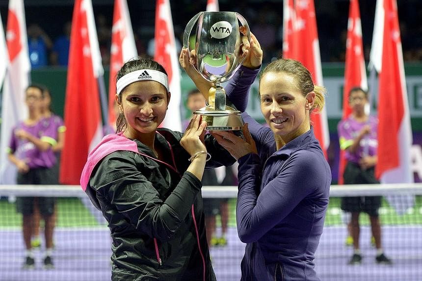 The pair of Zimbabwean Cara Black (right) and India's Sania Mirza won the BNP Paribas WTA Finals Singapore doubles title on Sunday afternoon in emphatic style, thrashing defending champions Peng Shuai and Hsieh Su-wei 6-1, 6-0 to lift the trophy. -- 
