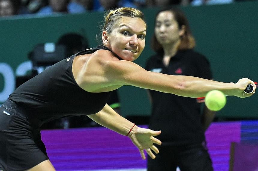 Simona Halep of Romania plays a shot against Serena Williams of the US during the finals of the Women's Tennis Association (WTA) finals in Singapore on Oct 26, 2014. -- PHOTO: AFP