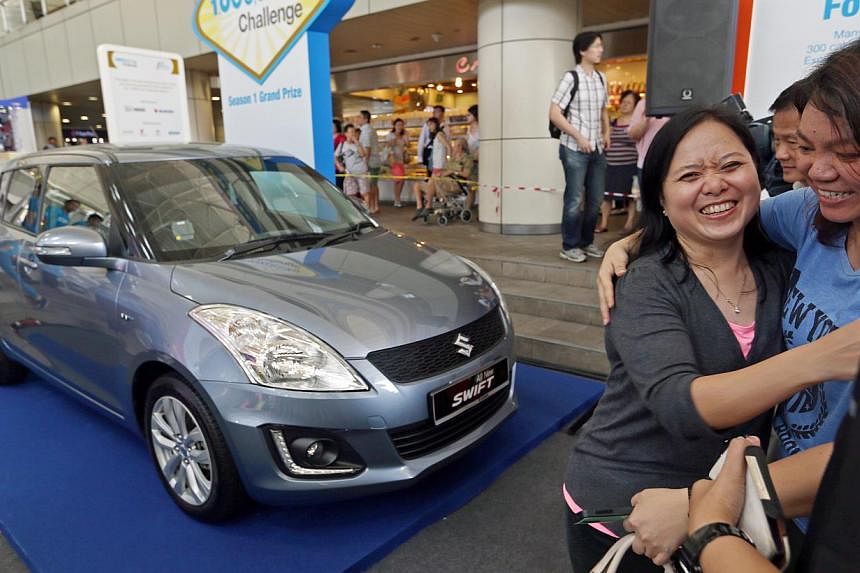Engineer Ting Yit Lai (above, in grey) being congratulated by friend Lani Lam, 31. She won the top prize of a car in the One Million KG Challenge draw, which is for 10 finalists randomly picked from participants who have lost at least 3kg since March
