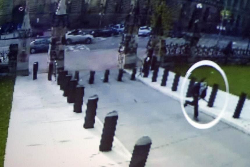 This image from a close circuit video shown during an Oct 23, 2014, press conference at Royal Canadian Mounted Police headquarters in Ottawa shows supected shooter Michael Zehaf-Bibeau (circled) running towards the Canadian Parliament. -- PHOTO: AFP