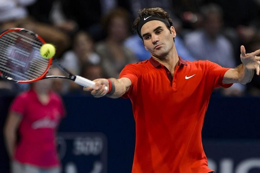 Roger Federer of Switzerland returns a ball during his semi final match against Ivo Karlovic of Croatia at the Swiss Indoors ATP 500 tennis tournament in Basel on Oct 25, 2014. -- PHOTO: AFP