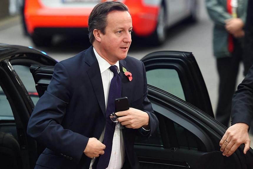Britain Prime Minister David Cameron arrives for a European Union summit at the EU headquarters in Brussels on Oct 24, 2014. -- PHOTO: AFP