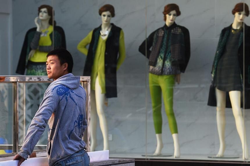 A construction worker outside a fashion outlet in Beijing. Spending continues to rise in China even though debts owed by the government, companies and households have swelled to 240 per cent of GDP, which some fear will undermine the country's commer