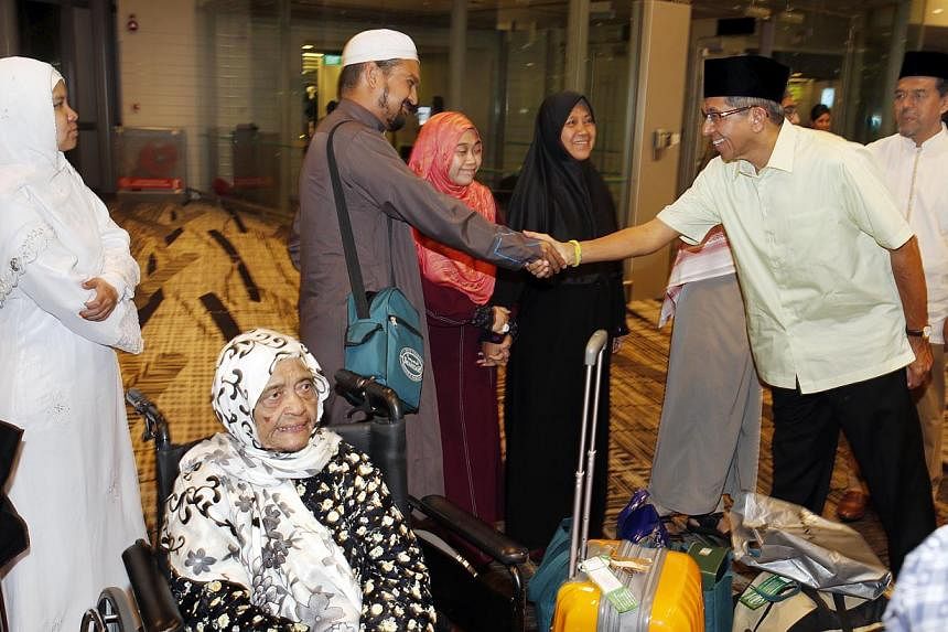 Dr Yaacob Ibrahim (right) greeting Mr Kamaludin Bahain, 42, at the airport yesterday. Also present are (from left) Ms Faizah Mah Atar, 42; Madam Siti Raudah Embar, 90; Ms Sharifah Nurhajar Syed Salleh, 28; and Ms Chik Ejah Ahmad, 55.