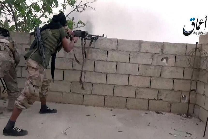 An image grab taken from a video uploaded on Oct 19, 2014, allegedly shows Islamic State in Iraq and Syria (ISIS) militants taking shooting positions in the town of Ain al-Arab, known by the Kurds as Kobane, on the Syria-Turkey border. A British scho