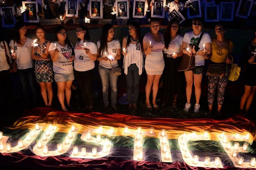 Protesters hold candles during a vigil inside the campus of the state university in Manila on Oct 24, 2014, to coincide with the burial of murdered transgender woman, Jennifer Laude, who was allegedly killed by US Marine Private First Class Joseph Sc