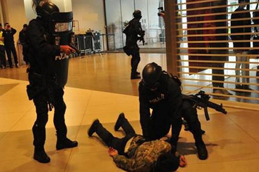 Special Operations Command (SOC) officers pin down a role player on the second day of Exercise Heartbeat, an annual anti-terror exercise by the Singapore Police Force at the IMM Building.&nbsp;-- PHOTO: SINGAPORE POLICE FORCE