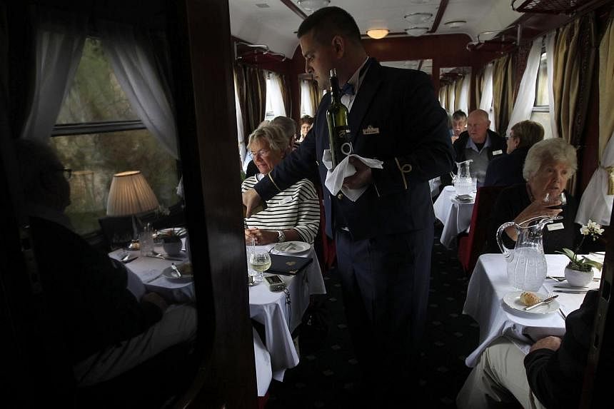 A waiter serves lunch on board a historic Teheran-bound train as it leaves Budapest on Oct 15, 2014. -- PHOTO: REUTERS