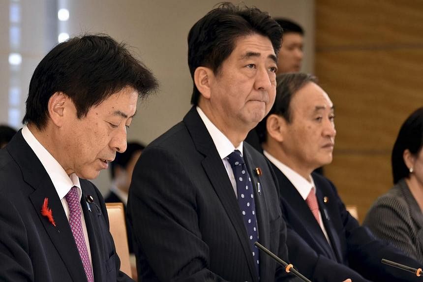 Japan's Prime Minister Shinzo Abe (second left), flanked by Labour, Health and Welfare Minister Yasuhisa Shiozaki (left), Chief Cabinet Secretary Yoshihide Suga (second right) and Internal Affairs and Communications Minister Sanae Takaichi (right), a