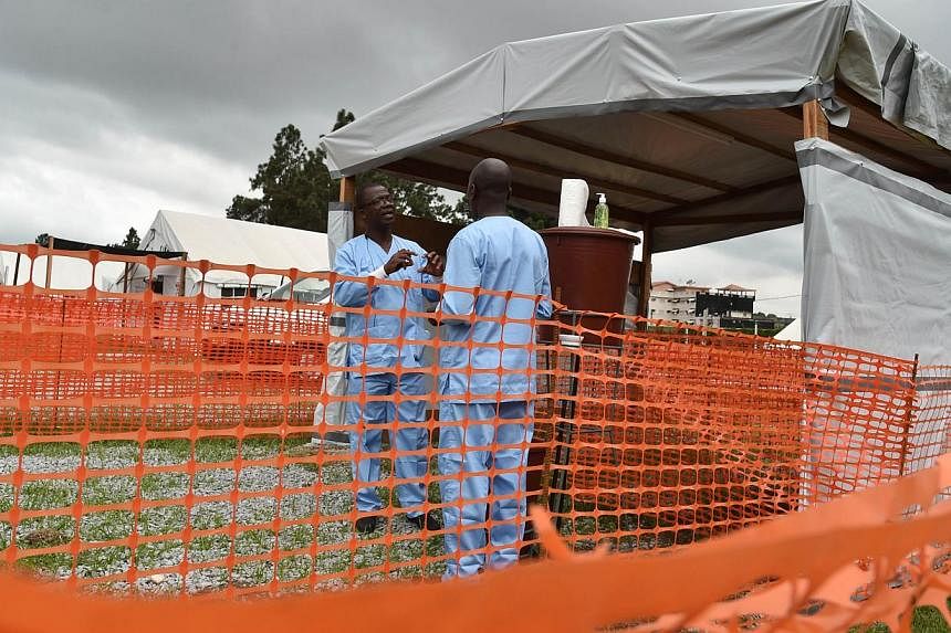 Health workers stand by an Ebola treatment unit being preventively set to host potential Ebola patients at the University Hospital of Yopougon in Abidjan on Oct 25, 2014. -- PHOTO: AFP