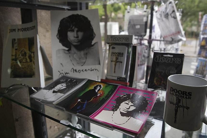 Souvenirs to remember the late American singer Jim Morrison displayed in a shop in the Pere-Lachaise cemetery in Paris on Oct 16, 2014. &nbsp;The Doors' singer who died at age 27 in 1971 in the French capital is buried in the cemetary. - PHOTO: AFP