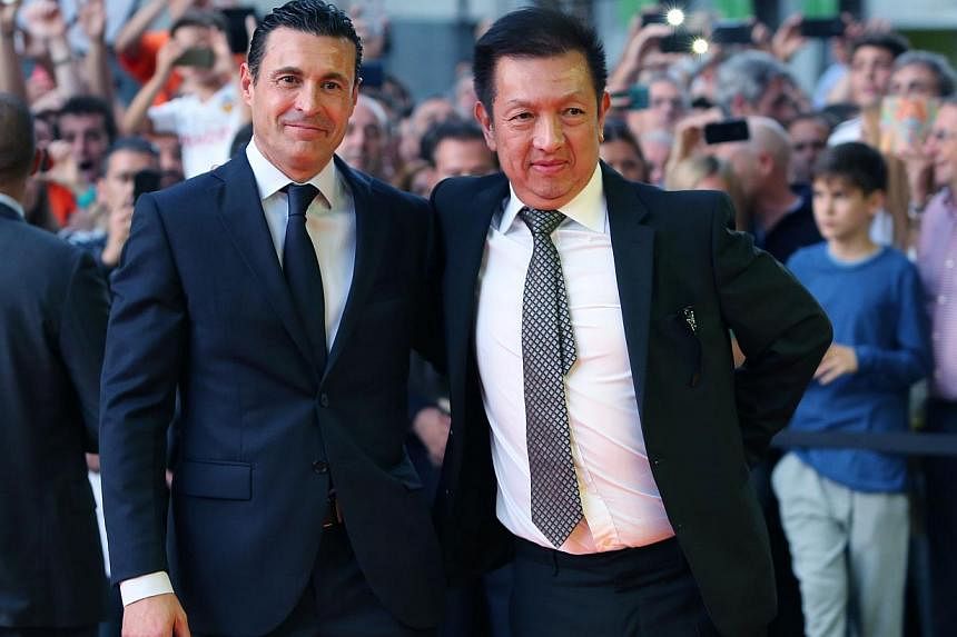 Valencia's new owner Peter Lim (right) and Valencia's President Amadeo Salvo pose during the Spanish league football match Valencia FC vs Elche CF at the Mestalla stadium in Valencia on Oct 25, 2014. -- PHOTO: AFP