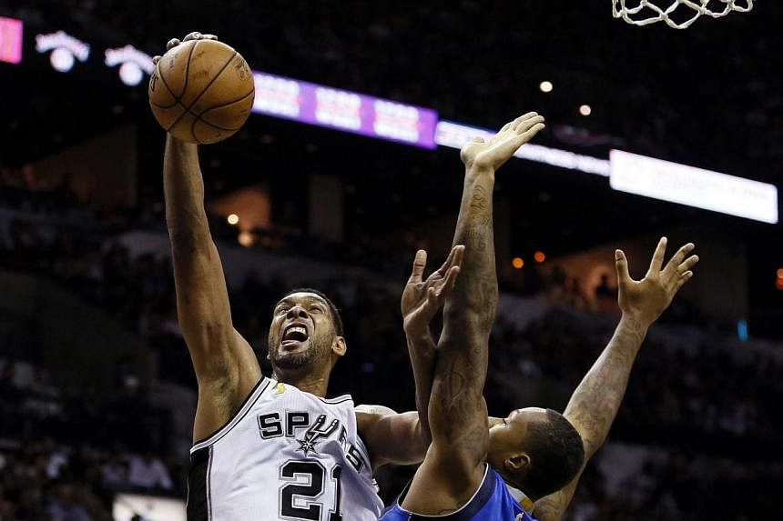 San Antonio Spurs power forward Tim Duncan (21) is fouled while shooting by Dallas Mavericks power forward Greg Smith (4) during the first half at AT&amp;T Centre.&nbsp;-- PHOTO: USA TODAY SPORTS