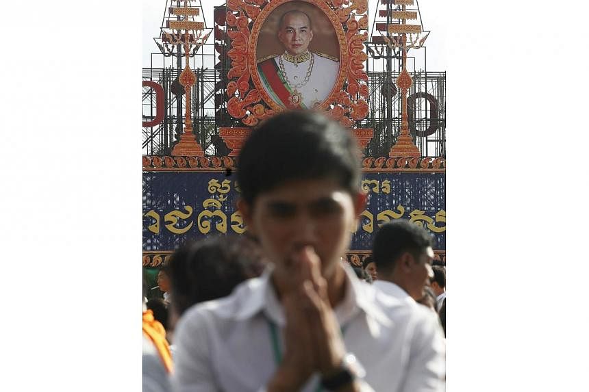 A man prays in front of a portrait of Cambodia's King Norodom Sihamoni displayed during a ceremony to mark the 10th anniversary of Sihamoni's coronation, in Phnom Penh on Oct 28, 2014.&nbsp;Thousands of well-wishers Wednesday celebrated the 10th anni