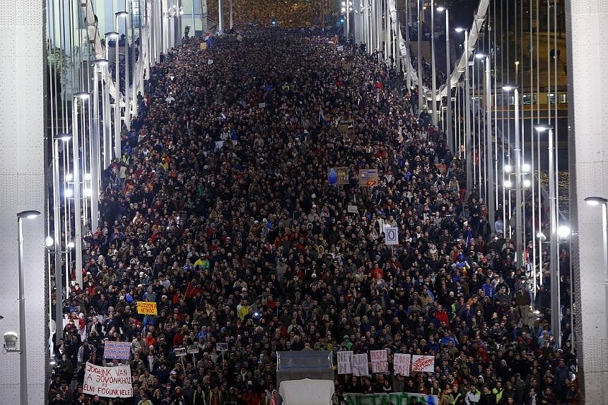 Ten of thousands of Hungarians march across the Elisabeth Bridge during a protest against a new tax on Internet data transfers in centre of Budapest, Oct 28, 2014. -- PHOTO: REUTERS